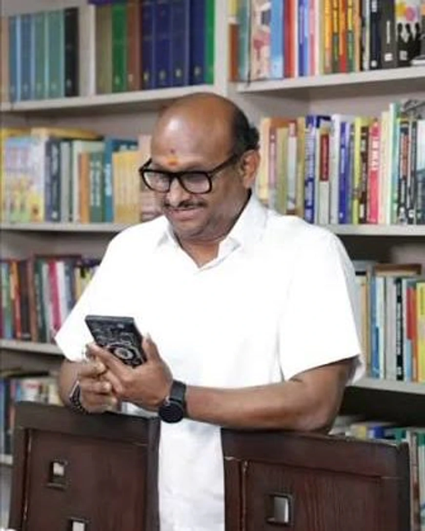 R.J. Bhuvanesh at the bookshelves in his office